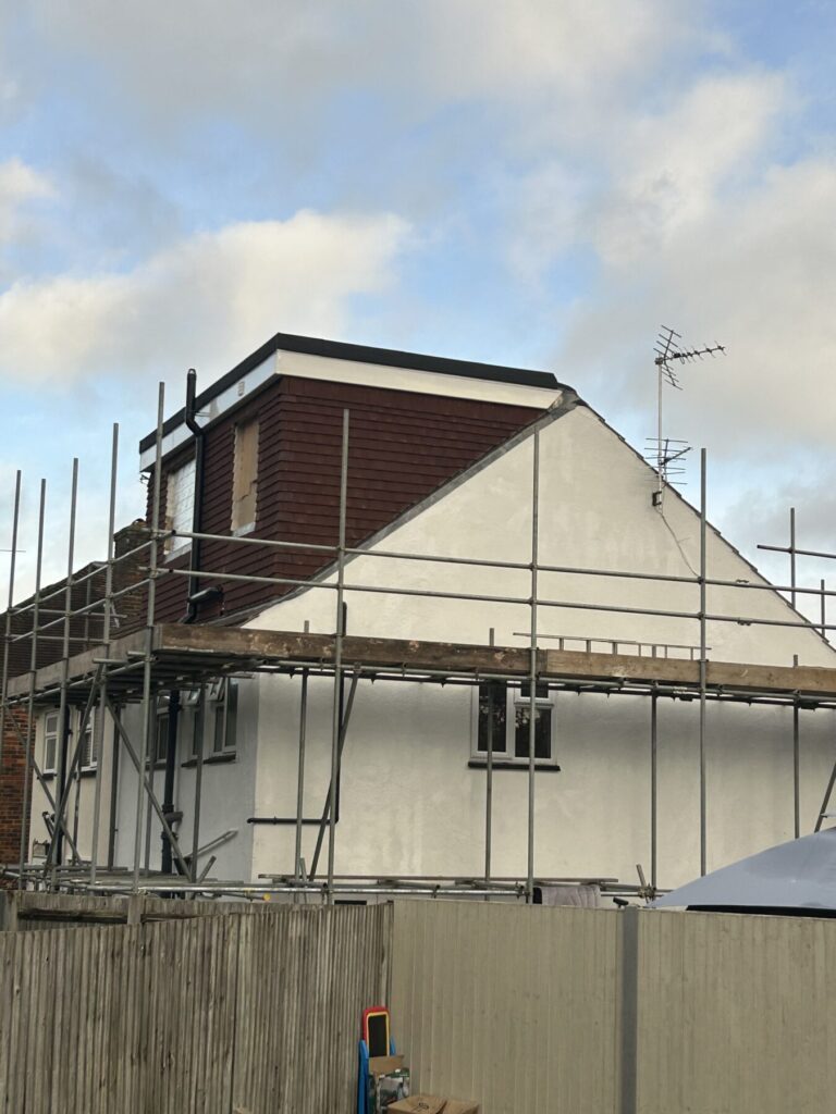 Professional dormer loft conversion with external timber cladding and scaffolding installation, showcasing high-quality residential construction work.